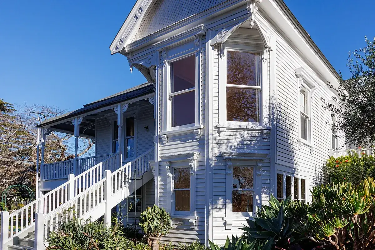 Stacked bay windows on the corner of a painted timber house