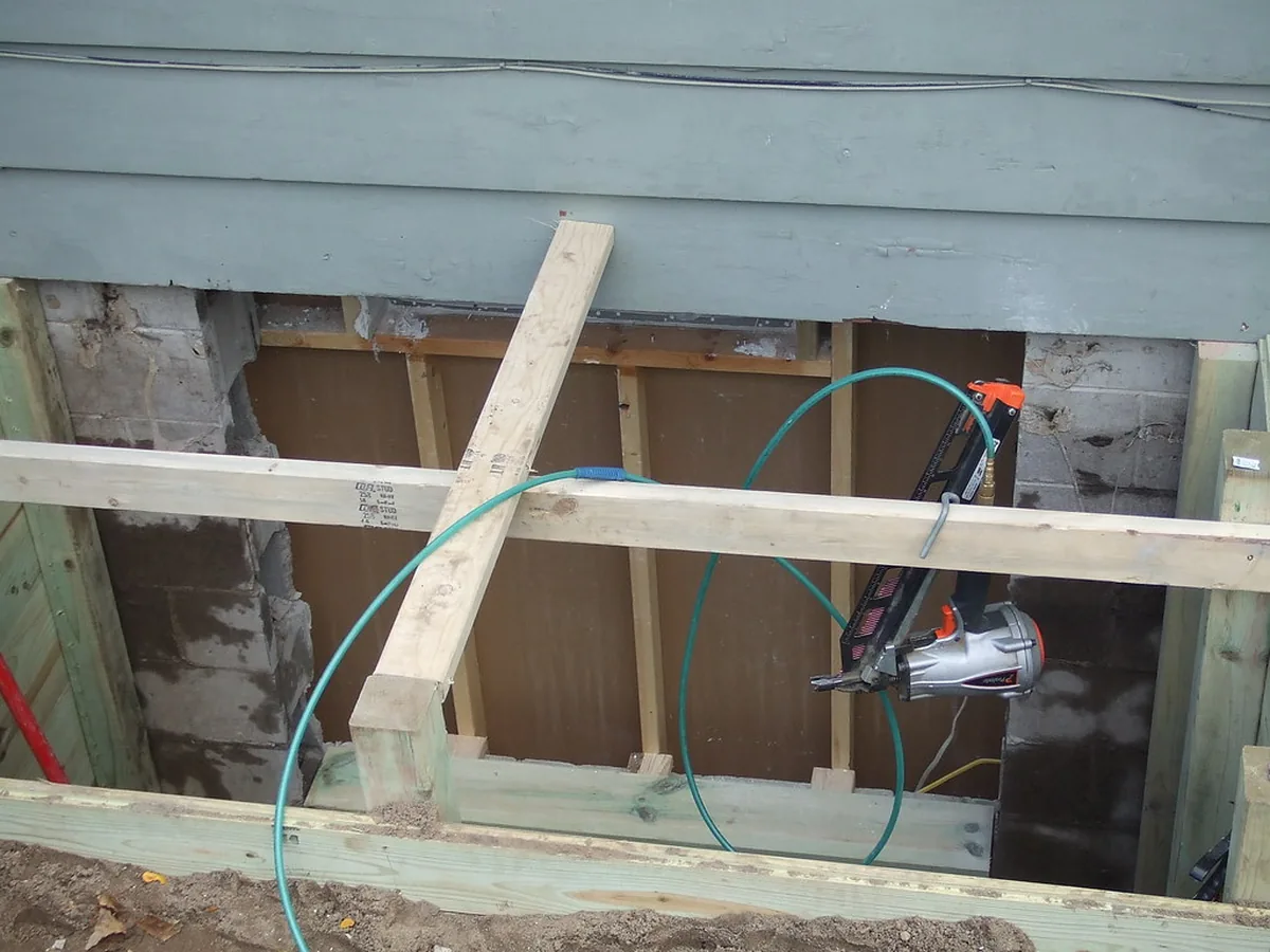 Basement egress window installation in McDonough GA under way: the old opening cut out, shored and framed in the foundation wall