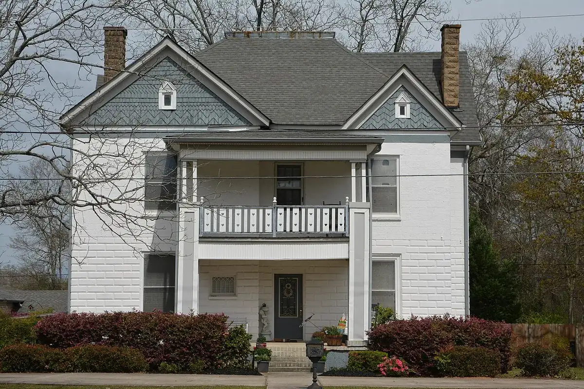 A white two-story house with a porch and a central front door, in the Locust Grove historic district, Georgia