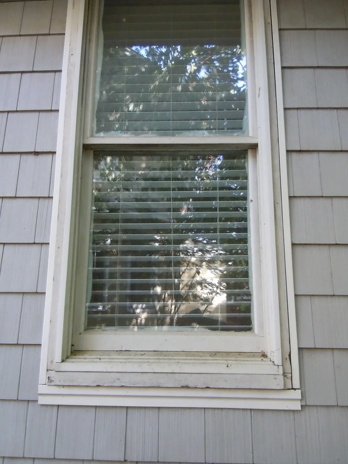 A weathered wooden sill under a window, the surface a sill rot repair in McDonough GA starts from